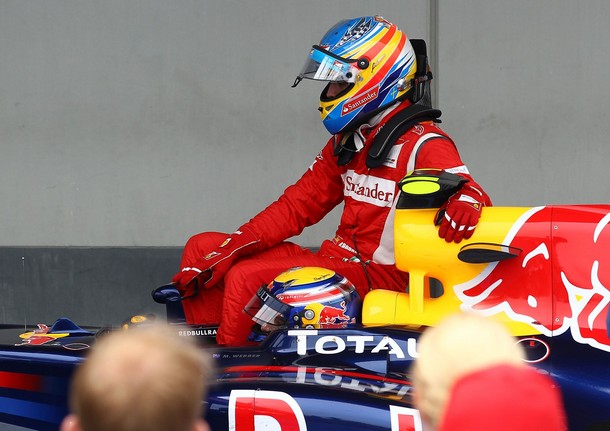 Fernando Alonso llega al pit-lane montado en el coche de Mark Webber