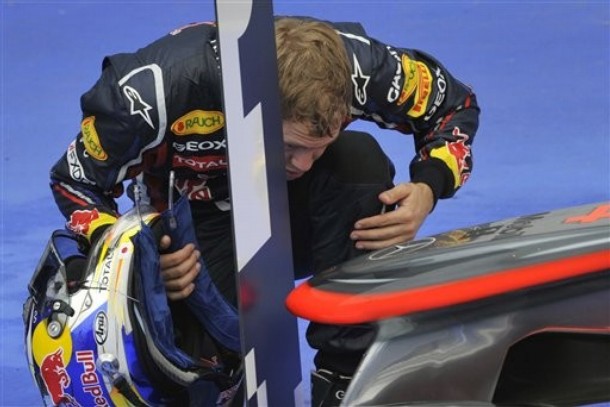 Sebastian Vettel observa el coche de Jenson Button tras el GP de Hungría 2011