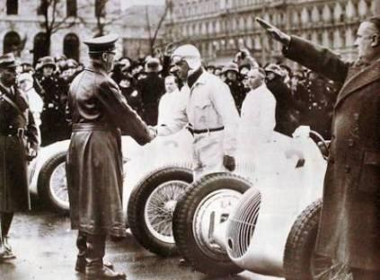 Caracciola saluda a Hitler con Neubauer de brazo alzado. 1937