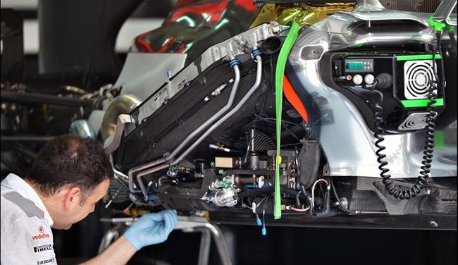 Mecánico de McLaren realizando ajustes en el MP4-28