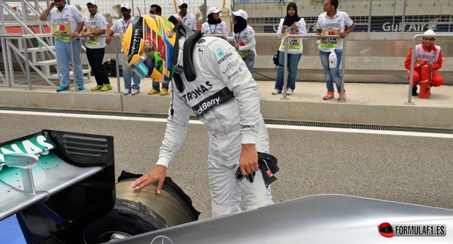 Lewis Hamilton mira su neumático sin banda de rodadura en Baréin 2013